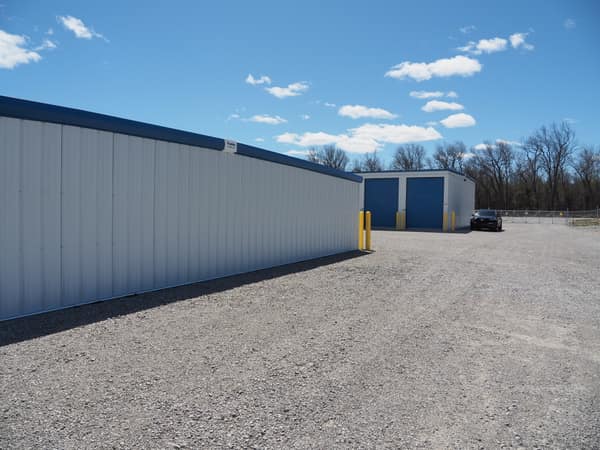 Paved drive aisle between Building D and a neighboring building, with drive-up access to every unit
