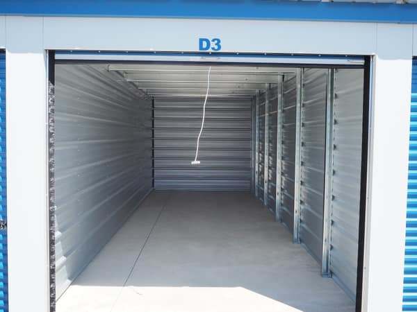 Inside a clean, empty Building D storage unit with pull-cord light