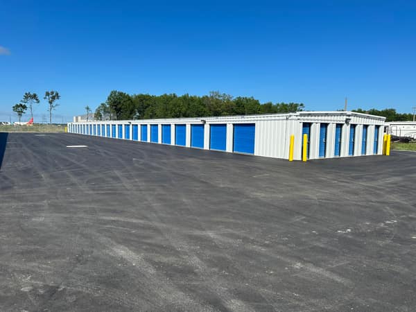 Phase 1 buildings across the paved lot under a blue sky