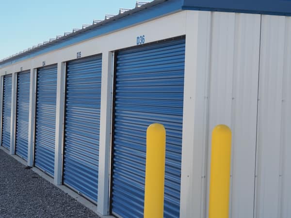 Row of Building D units (D33–D36) with yellow safety bollards